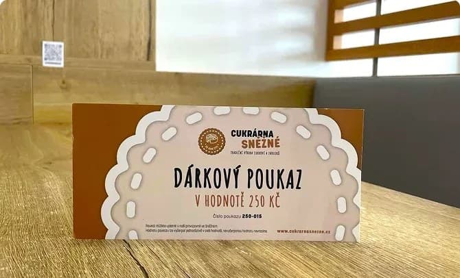 Dárkový poukaz Cukrárny Sněžné na stole v kavárně